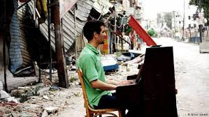 Aeham Ahmad am Piano in den Trümmern von Yarmouk